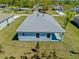 New construction home featuring a light blue exterior, a modern roof, and verdant landscaping at 1301 Preston St, Port Charlotte, FL 33952