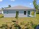New construction with backyard featuring windows and door leading to a covered patio at 1301 Preston St, Port Charlotte, FL 33952