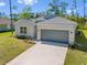 Exterior view of a single-Gathering home with a two-car garage and landscaping at 1301 Preston St, Port Charlotte, FL 33952