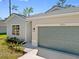 Charming home exterior showing a blue garage door and landscaped front yard at 1301 Preston St, Port Charlotte, FL 33952