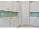 Kitchen featuring white cabinets, quartz countertops and blue tile backsplash at 1301 Preston St, Port Charlotte, FL 33952