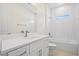 Bathroom featuring subway tiled shower, white vanity and quartz countertop at 1415 Nackman Rd, North Port, FL 34288