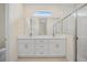 Bathroom featuring double vanity with white cabinets, quartz counters and glass-enclosed shower with subway tile at 1415 Nackman Rd, North Port, FL 34288