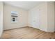 Bedroom with wood-look flooring, light walls, window, and a closet with double doors at 1415 Nackman Rd, North Port, FL 34288