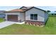 Attractive single Gathering home boasts stone facade, lush lawn, and desirable two car garage at 1415 Nackman Rd, North Port, FL 34288