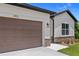 A two car garage featuring address numbers and stone facade enhances the home's curb appeal at 1415 Nackman Rd, North Port, FL 34288