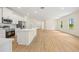 Open concept living room next to the kitchen with light walls and wood flooring at 1415 Nackman Rd, North Port, FL 34288