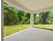 View of the outdoor patio overlooking a lush green yard filled with mature landscaping at 1415 Nackman Rd, North Port, FL 34288