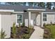 Front entrance with a white door and walkway, surrounded by landscaping at 1492 Biscayne Dr, Port Charlotte, FL 33953