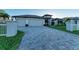 Spacious driveway with a three-car garage and landscaping at 17389 Ohara Dr, Port Charlotte, FL 33948