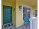 Charming front porch with a green door, a window, and a blue chair, creating a welcoming and cozy entrance at 2000 Bal Harbor Blvd # 321, Punta Gorda, FL 33950