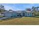 Front view of a teal house with a neatly kept lawn at 2335 Music Ln, North Port, FL 34286