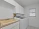 Laundry room features cabinets, sink, washer, and dryer at 25373 Tether Ln, Punta Gorda, FL 33983