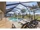 Inviting pool area with screened enclosure, lounge chairs, and tranquil view at 25373 Tether Ln, Punta Gorda, FL 33983