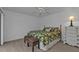 Guest bedroom with leafy bedding, dresser, and two ottomans at 25373 Tether Ln, Punta Gorda, FL 33983