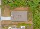 Aerial view of a well-maintained house, surrounded by green trees, with a light gray roof and long driveway at 2643 Rushmore St, North Port, FL 34288