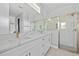 Bathroom with quartz countertops, dual sinks, subway tile shower, and glass enclosure at 2643 Rushmore St, North Port, FL 34288