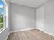 This bedroom features light wood flooring, a window, a door, and neutral walls at 2643 Rushmore St, North Port, FL 34288