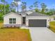 Charming single-story home featuring a two-car garage, landscaped yard, and neutral-toned exterior at 2643 Rushmore St, North Port, FL 34288