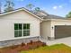 Close-up of home showcasing brick accents, neutral colors and professional landscaping at 2643 Rushmore St, North Port, FL 34288