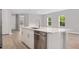 Bright kitchen with stainless steel appliances, white cabinets, a quartz island and ample counter space at 2643 Rushmore St, North Port, FL 34288