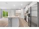 Modern kitchen with stainless steel appliances, white cabinets, a quartz island, and a door to the patio at 2643 Rushmore St, North Port, FL 34288
