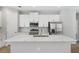 Modern kitchen featuring white cabinets, stainless steel appliances, and a large quartz island at 2643 Rushmore St, North Port, FL 34288
