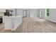 Open floor plan of the living and kitchen area featuring wood floors, ample natural light, and modern finishes at 2643 Rushmore St, North Port, FL 34288