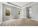 Spacious bedroom with tray ceiling, wood-look floors, and two windows offering natural light at 2643 Rushmore St, North Port, FL 34288