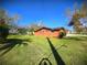 Ranch-style home with orange exterior and a large yard at 301 Country Club Way, Venice, FL 34285
