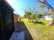 Landscaped side yard with grass, trees, and privacy screen at 301 Country Club Way, Venice, FL 34285