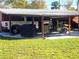 Covered carport with space for vehicles and outdoor seating at 301 Country Club Way, Venice, FL 34285