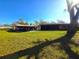 Backyard view of home showcasing covered patio and large yard at 301 Country Club Way, Venice, FL 34285