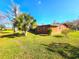 Ranch-style home with orange exterior and a large yard at 301 Country Club Way, Venice, FL 34285