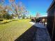 Large backyard with grassy area, covered patio, and golf cart at 301 Country Club Way, Venice, FL 34285