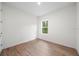 Simple bedroom with wood-look floors and a window providing natural light at 3705 Baynes Rd, North Port, FL 34288