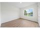 Well-lit bedroom featuring wood-look floors and a window at 3705 Baynes Rd, North Port, FL 34288