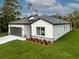 Low angle exterior of a single-story home with a manicured lawn, 2-car garage, and a dark gray roof at 3705 Baynes Rd, North Port, FL 34288