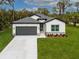 Charming single-story home with gray roof, dark gray garage door, and well-manicured lawn at 3705 Baynes Rd, North Port, FL 34288