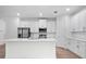 Island kitchen with white shaker cabinets, stainless steel appliances, and quartz countertops at 3705 Baynes Rd, North Port, FL 34288