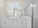 A modern bathroom featuring double sinks, white cabinets, and glass-enclosed shower at 3779 Clearfield St, North Port, FL 34286