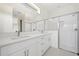 A modern bathroom featuring double sinks, white cabinets, and glass-enclosed shower at 3779 Clearfield St, North Port, FL 34286