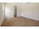 A spacious bedroom with wood flooring, base molding, and a doorway to a bathroom at 3779 Clearfield St, North Port, FL 34286
