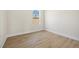 Empty room showcasing the wood flooring, baseboards, window, and natural light at 3779 Clearfield St, North Port, FL 34286