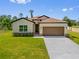 Charming single-story home featuring a two-car garage, manicured lawn, and neutral color palette at 3779 Clearfield St, North Port, FL 34286