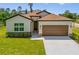 Charming single-Gathering home featuring a manicured lawn, a two-car garage, and a welcoming entrance with stone accents at 3779 Clearfield St, North Port, FL 34286