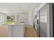 Modern kitchen with white cabinets, stainless steel appliances, and island with breakfast bar at 3779 Clearfield St, North Port, FL 34286