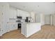 Modern kitchen featuring white cabinets, stainless steel appliances, a central island, and plenty of counter space at 3779 Clearfield St, North Port, FL 34286