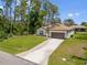 Inviting single-Gathering house with a spacious front yard and a long driveway leading to the garage at 3802 Eagle Pass St, North Port, FL 34286