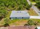 An aerial view of a single-Gathering home showcasing the gray roof and lush palm trees at 3883 Dominic St, North Port, FL 34288